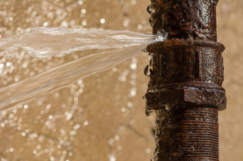 old pipe bursting with water